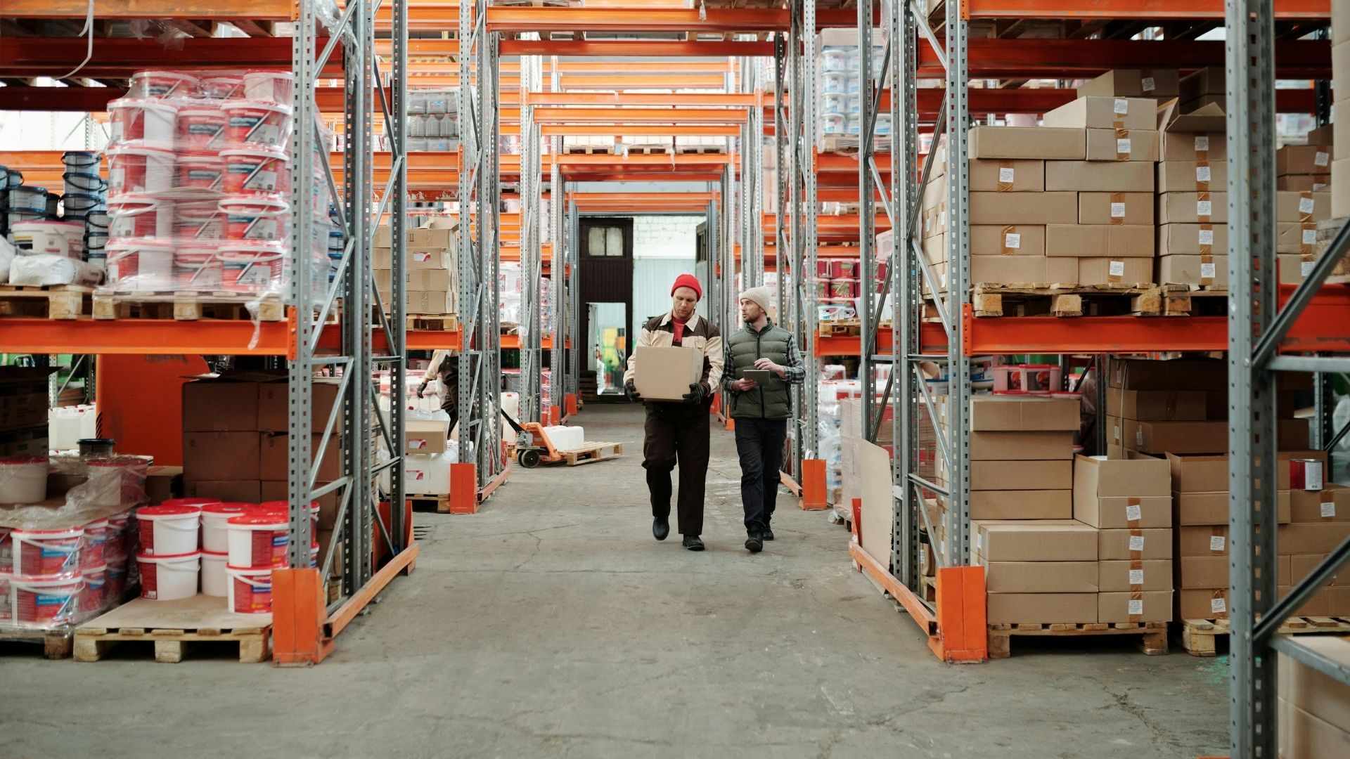 Workers walking through warehouse aisle